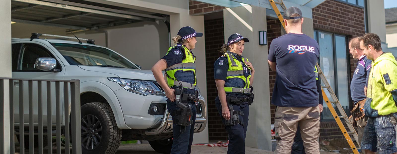 Police officers speaking with tradesmen.