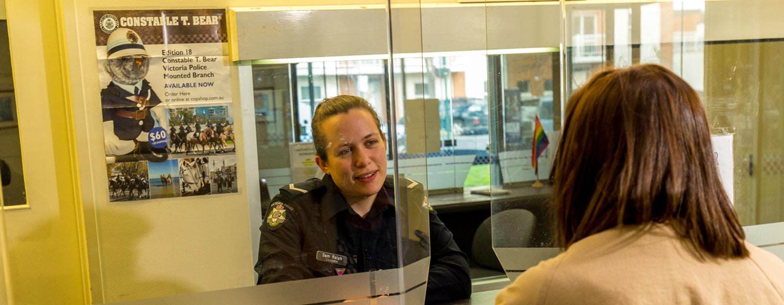 Polcie officer speaks with a woman at a police station