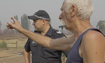 Police officer speaks with community member from Walwa.