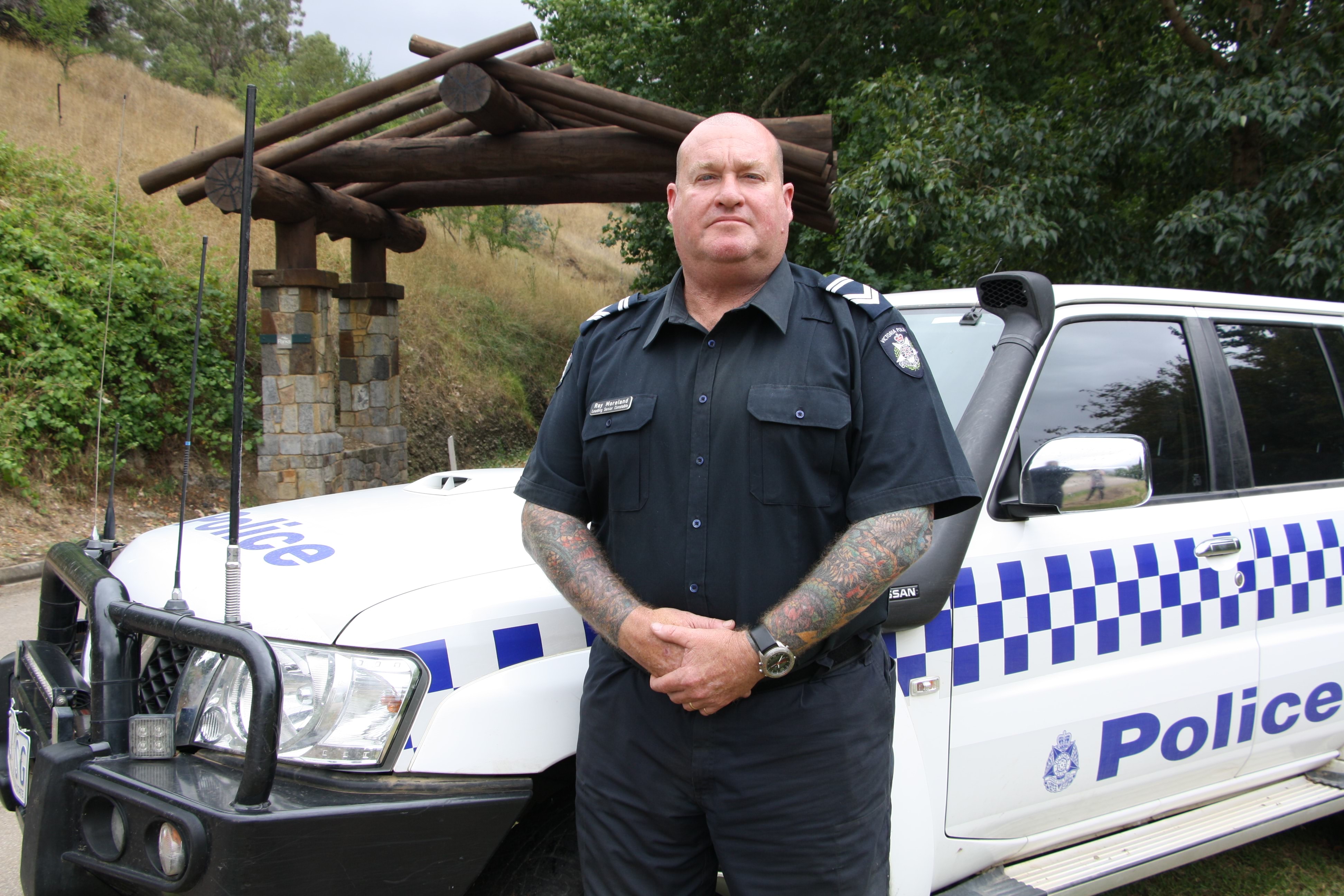 Police officer standing by his vehicle.