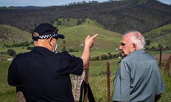 Police officer with Community member looking over to the hill