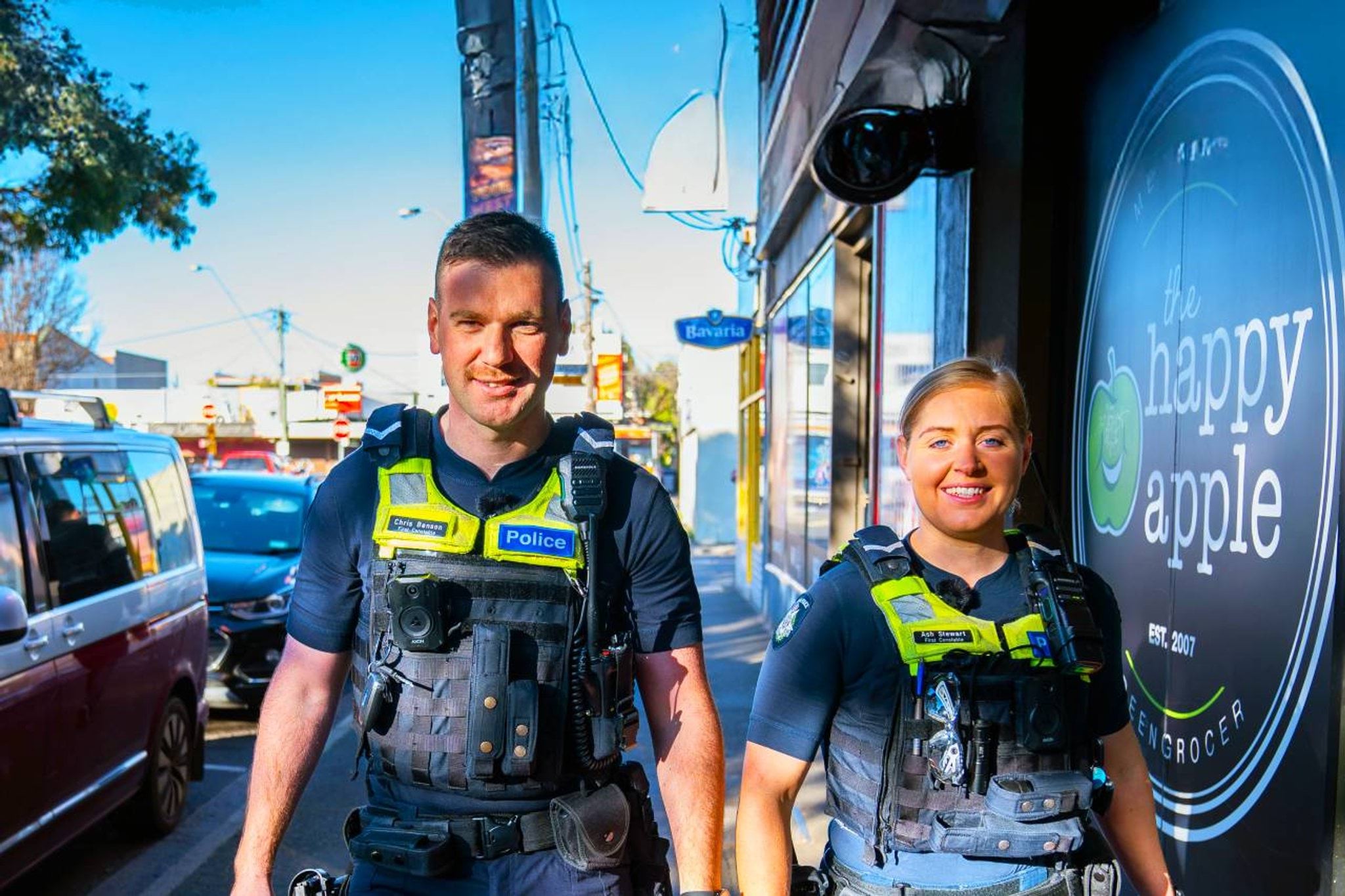 Two smiling officers walking on the street