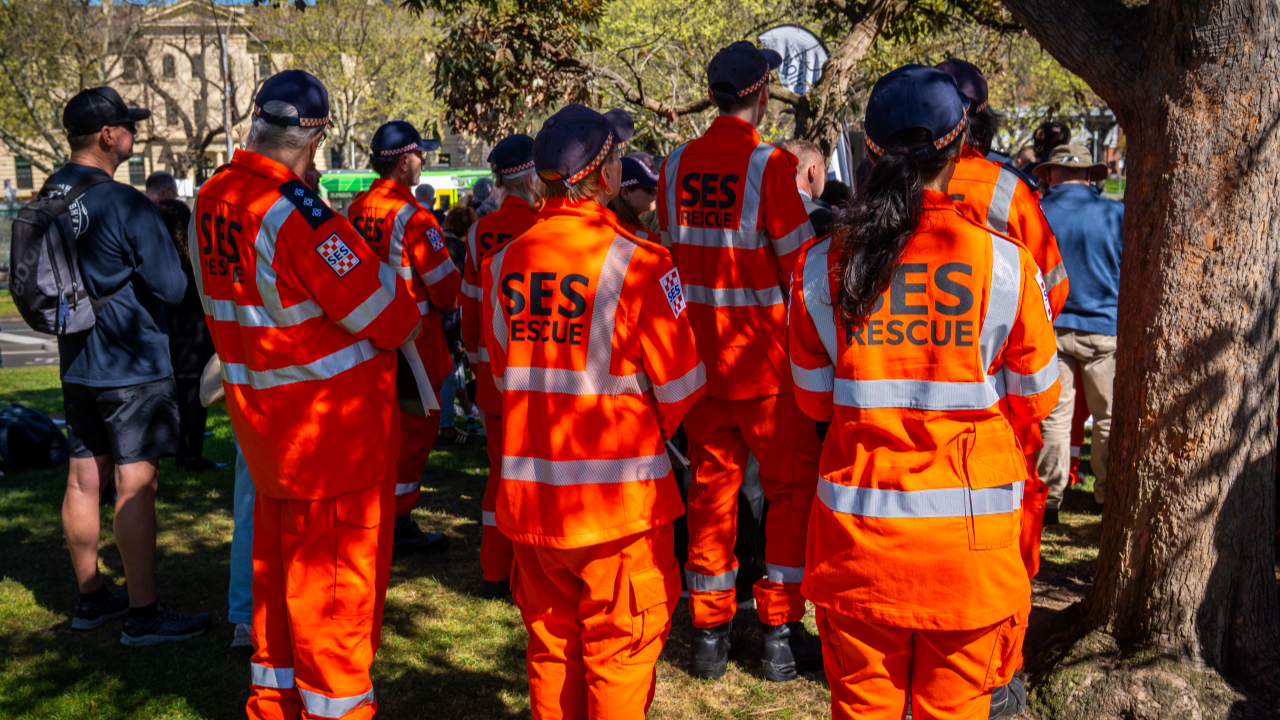 Members of Victoria State Emergency Service, wearing their orange uniforms, pay their respects at the Service. 