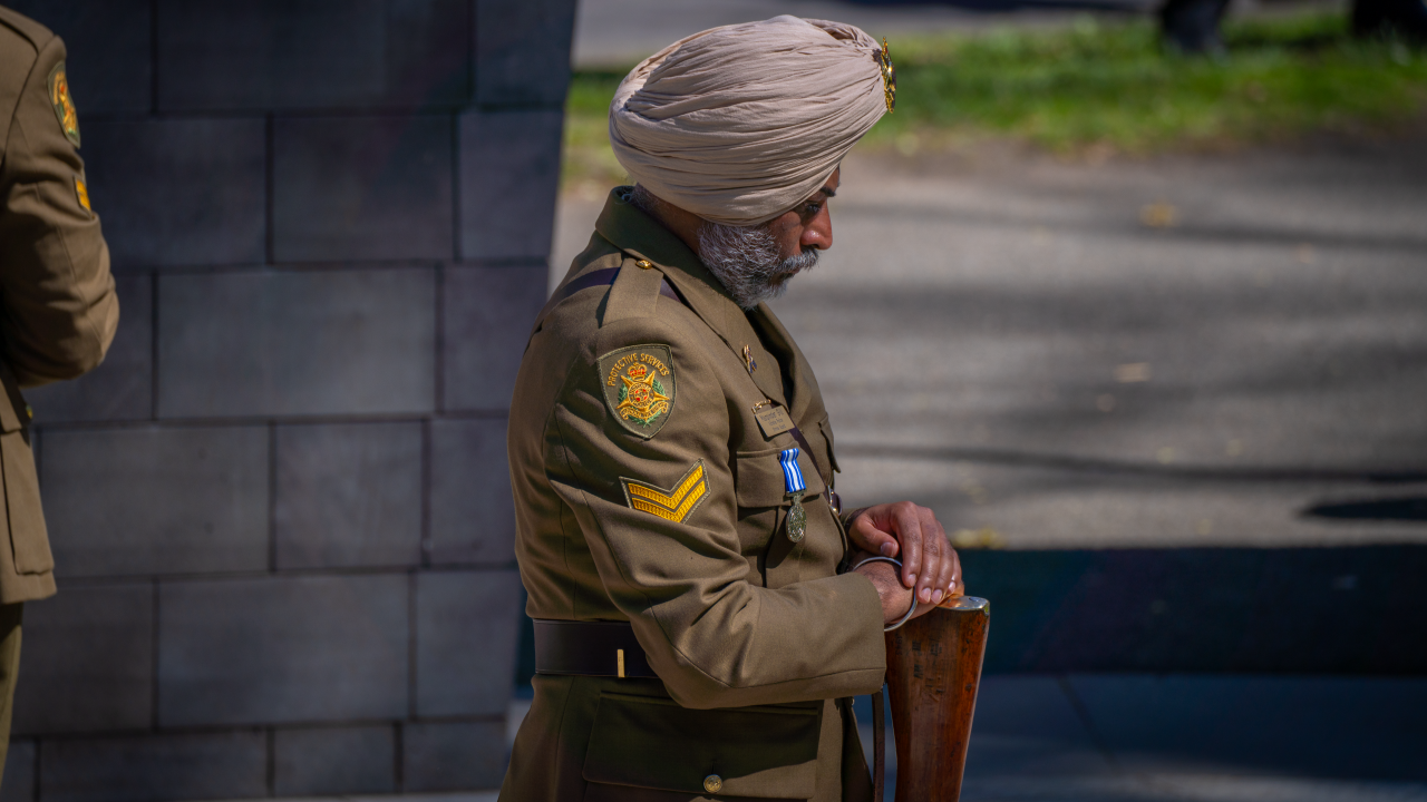 A Protective Services Shrine Guard bows his head as he stands at the Police Memorial. 